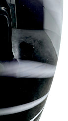 A sleek, hand-blown Polish art glass vase featuring a tall, slender neck that flares into a rounded, bulbous body. The vase is made of opaque black glass decorated with a continuous white spiral ribbon that winds around the entire piece from base to rim. The high-gloss, reflective surface creates sharp highlights, emphasizing its smooth, sculptural silhouette against a plain white background.
