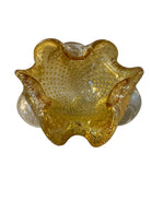 A  vintage Italian Murano glass bowl with a yellow hue, gold Aventurine inclusions, and a bubbly (Bullicante) texture. The bowl is flower-shaped with crimped edge