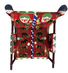 Close-up of a Yoruba beaded armchair, featuring vibrant red, blue, and green beads in a pattern of stylized masks and animals such as lions and zebras