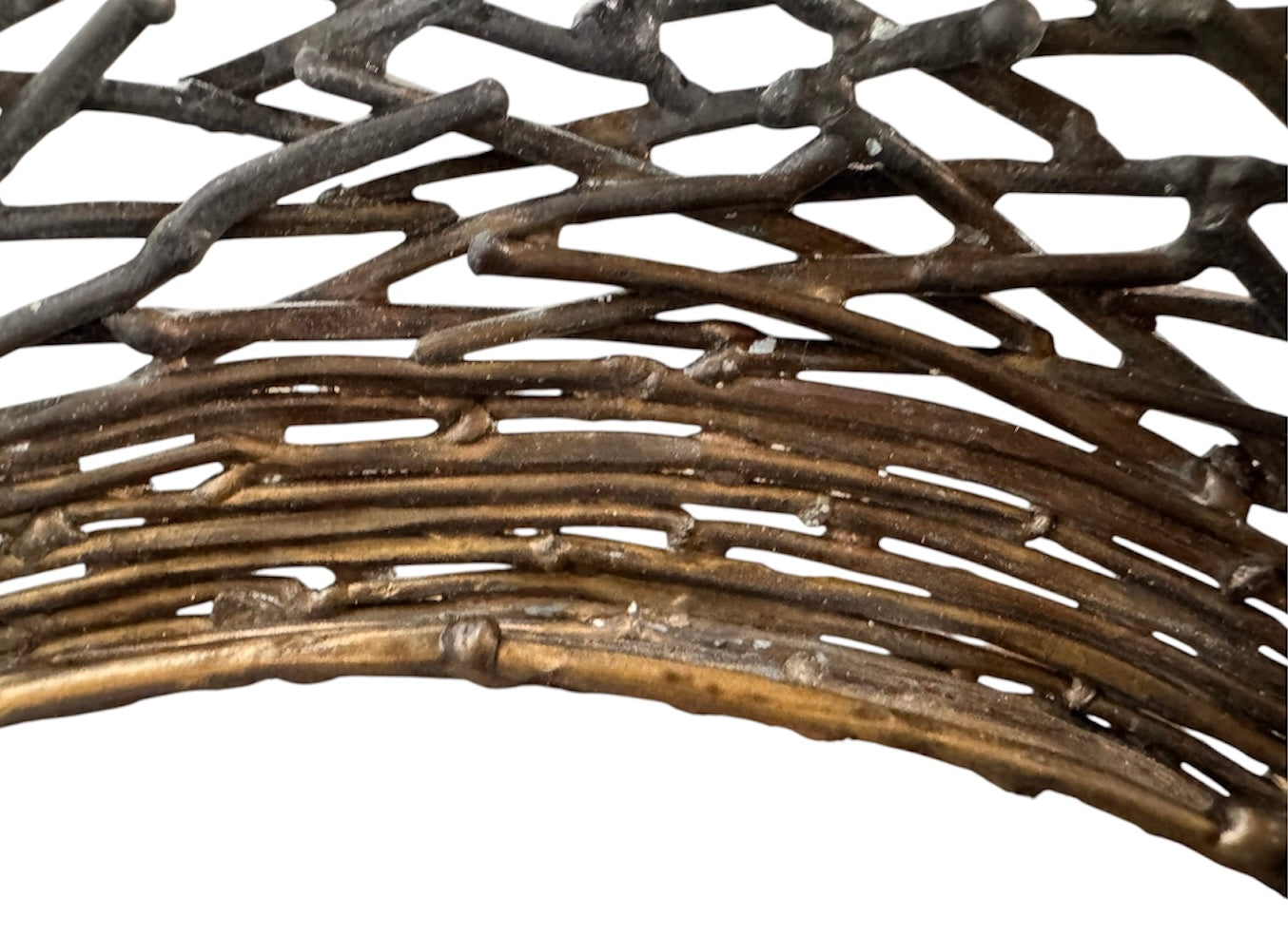 A round metal wall sculpture by Michael Aram, viewed from the front against a stark white background. The piece is composed of a dense, intricate lattice of fine, dark metal wire or twigs woven together to create a textured, web-like pattern. The structure curves inward like a funnel or a vortex, sloping down toward a clean, circular opening in the exact center, creating a strong sense of depth and dimensionality.