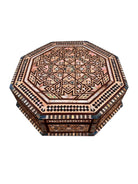 An ornate octagonal Syrian inlaid box, intricately decorated with geometric patterns made from dark wood, iridescent mother-of-pearl, vibrant abalone shell, and pale bone