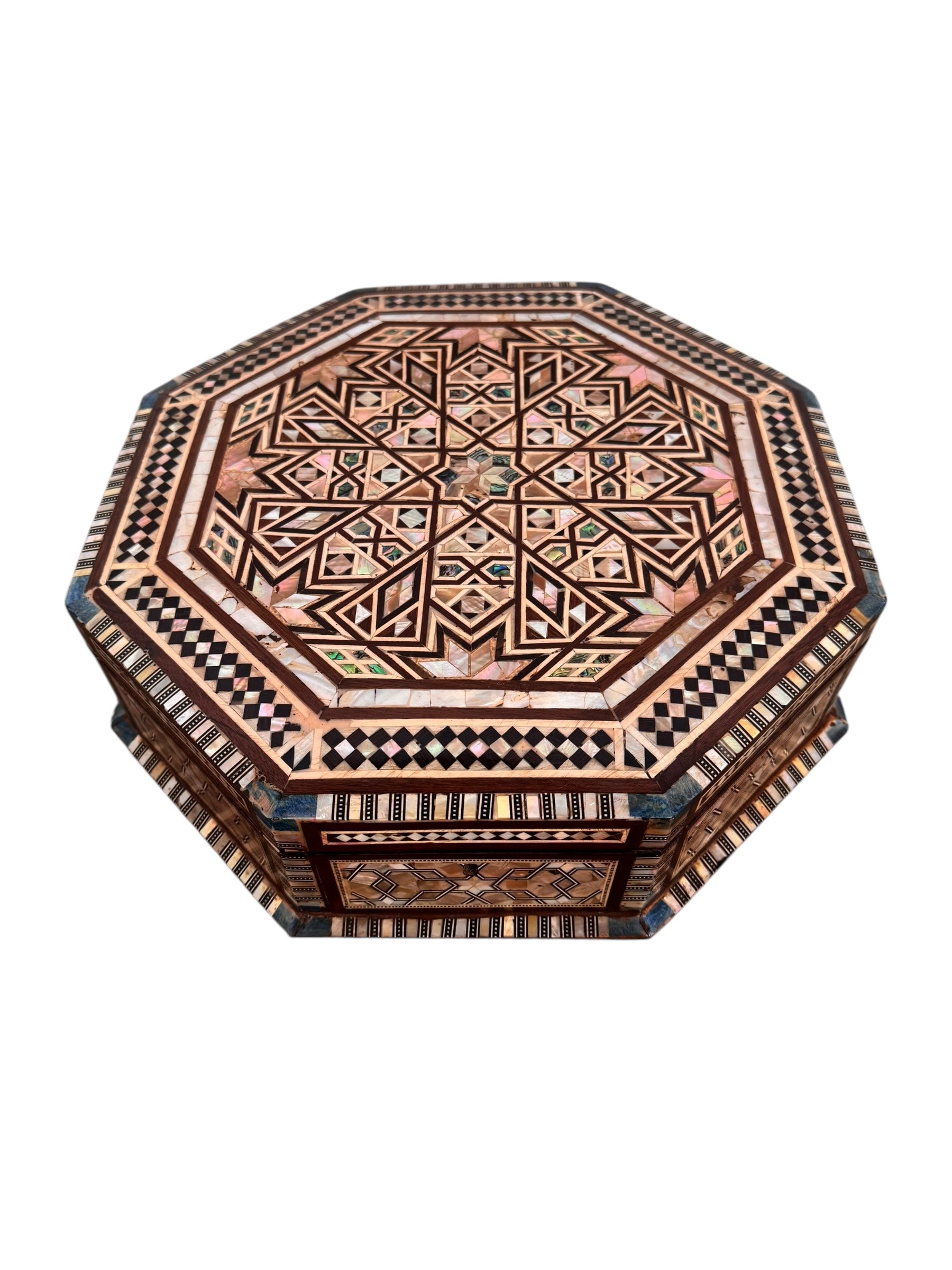 An ornate octagonal Syrian inlaid box, intricately decorated with geometric patterns made from dark wood, iridescent mother-of-pearl, vibrant abalone shell, and pale bone