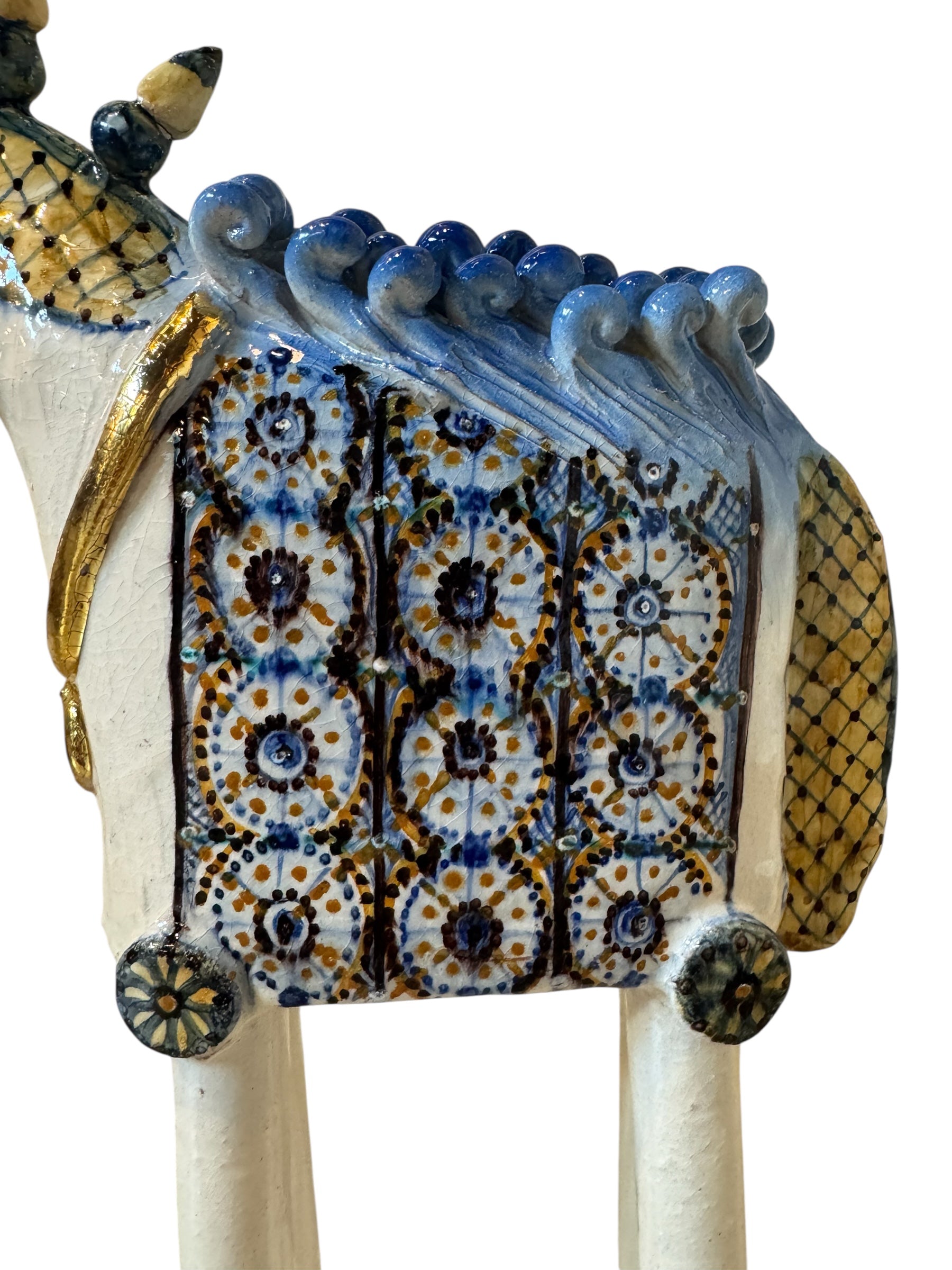 Ceramic horse by Domenico Pinto, featuring a white glazed body, geometric quilting on the saddle, a decorative crown with black and gold accents, and 24Kt gold detailing. The horse stands on four legs and is placed on a white base.