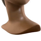 a vintage ceramic bust featuring a woman with brown skin, dark eyes, and orange lips. Her black hair is sleek and parted on the side, pulled back into a low style. She wears a small, round white earring in her right ear lobe. The bust includes her head, neck, and the upper part of her shoulders