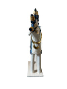 Ceramic horse by Domenico Pinto, featuring a white glazed body, geometric quilting on the saddle, a decorative crown with black and gold accents, and 24Kt gold detailing. The horse stands on four legs and is placed on a white base.