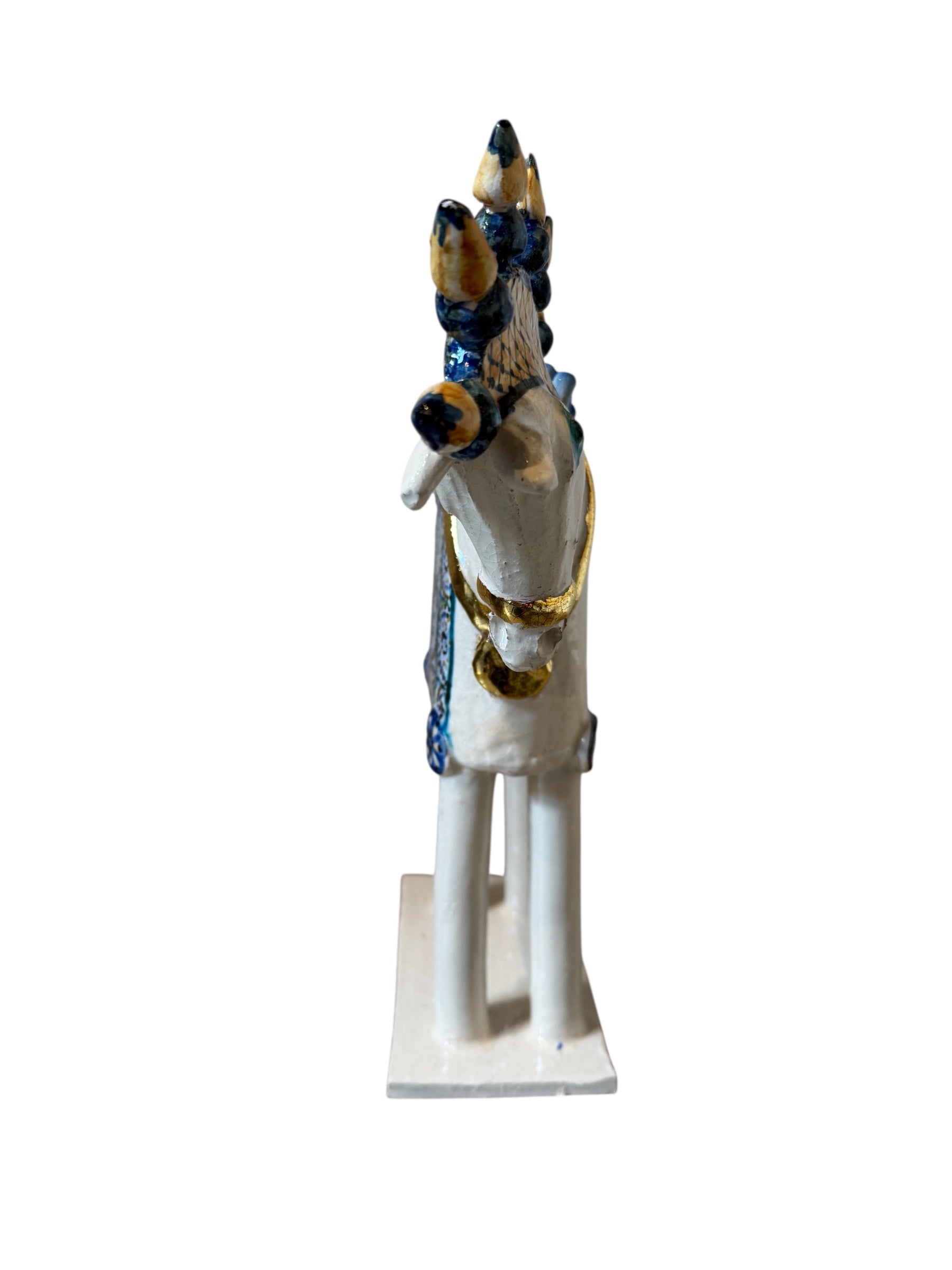 Ceramic horse by Domenico Pinto, featuring a white glazed body, geometric quilting on the saddle, a decorative crown with black and gold accents, and 24Kt gold detailing. The horse stands on four legs and is placed on a white base.