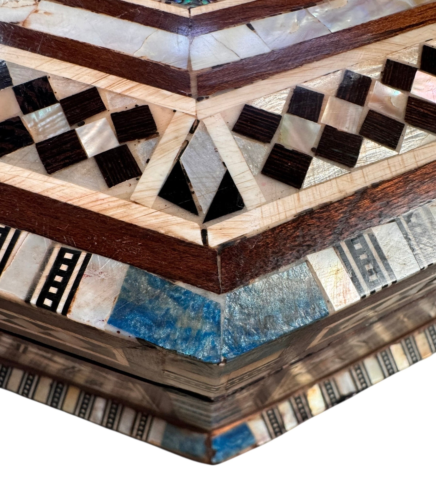 An ornate octagonal Syrian inlaid box, intricately decorated with geometric patterns made from dark wood, iridescent mother-of-pearl, vibrant abalone shell, and pale bone