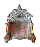 A pair of antique, heavily carved Anglo-Indian style throne chairs featuring lion figures as legs and arm supports, and peacock motifs on the backrests. The chairs have a distressed, multi-colored painted finish.