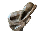 Figural sculpture in the Shona style, Zimbabwe. Two abstracted figures are intertwined, carved from greenish-brown soapstone. Sculpture rests on a dark iron stand.