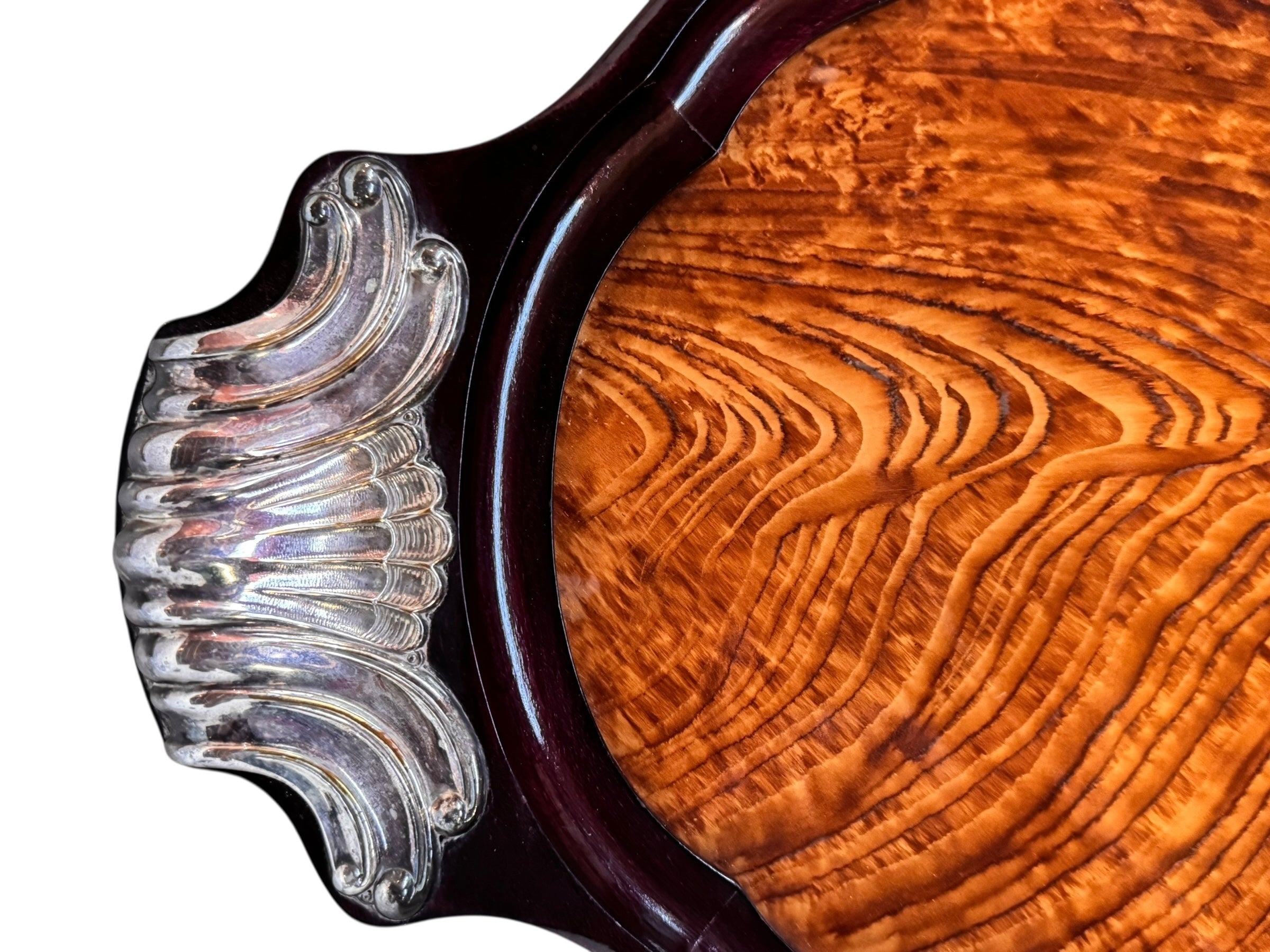 An ornate Art Deco serving tray featuring a highly figured burlwood center and silver-plated handles and rim