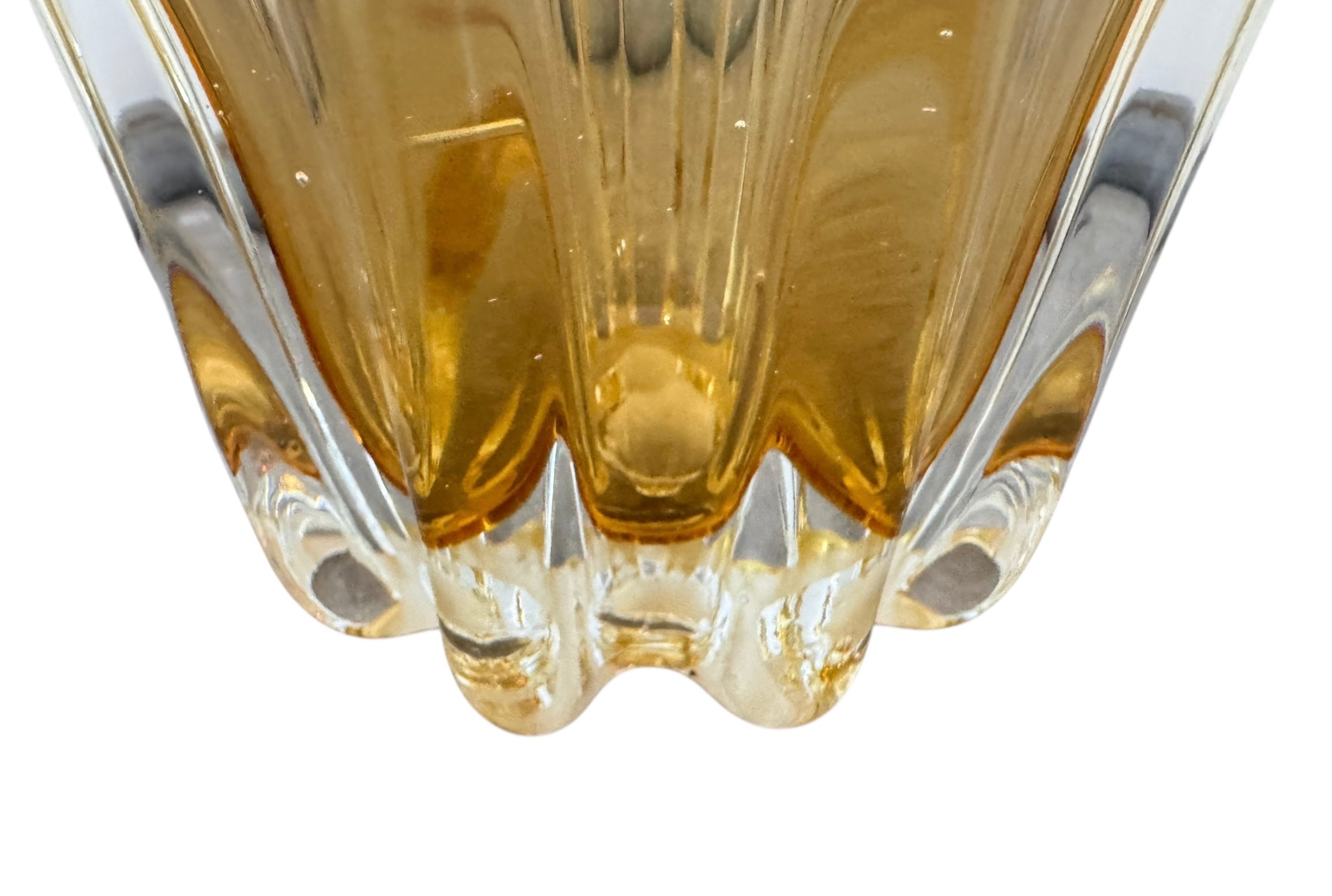 A hand-blown art glass vase with a scalloped, tulip-shaped rim, featuring an amber-to-clear color gradient and a ribbed base