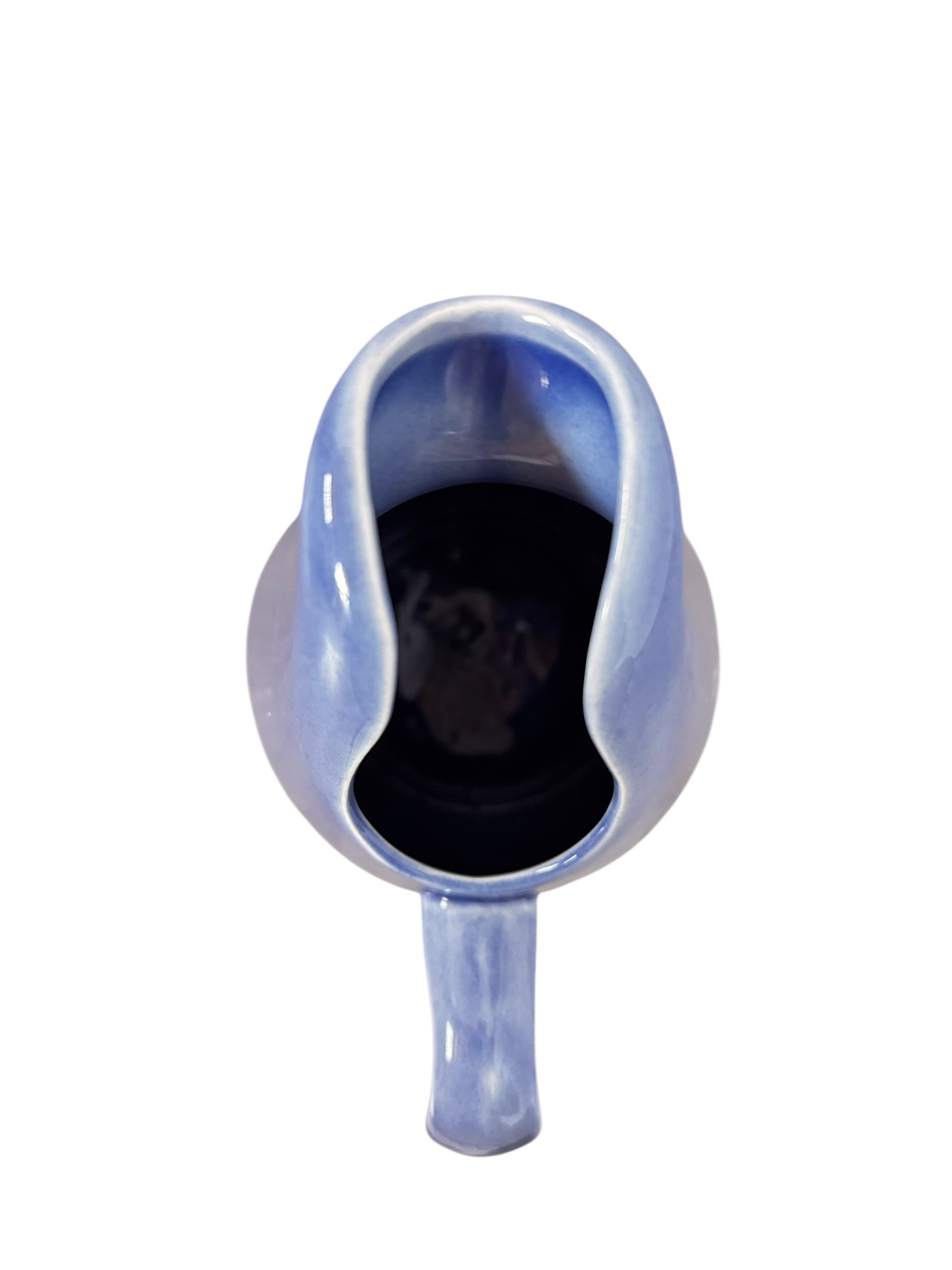 A Russel Wright American Modern stoneware water pitcher in a glossy Manitoga blue glaze is centered against a white background. The pitcher has a teardrop shape, a large handle, and a wide spout