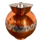 The set includes a large, rectangular, hammered copper tray with geometric openwork handles. Resting on the tray is a tall, slightly tapered copper coffee pot with a wooden handle, a matching smaller creamer pitcher with a similar wooden handle, a lidded sugar bowl, and a tiny matching metal cup or jigger. To the right off the tray sits a large, spherical copper water pitcher or jug with a wide mouth and ice lip.
