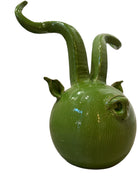 Glossy green ceramic pig sculpture with exaggerated, upward-curving horns and a snout.