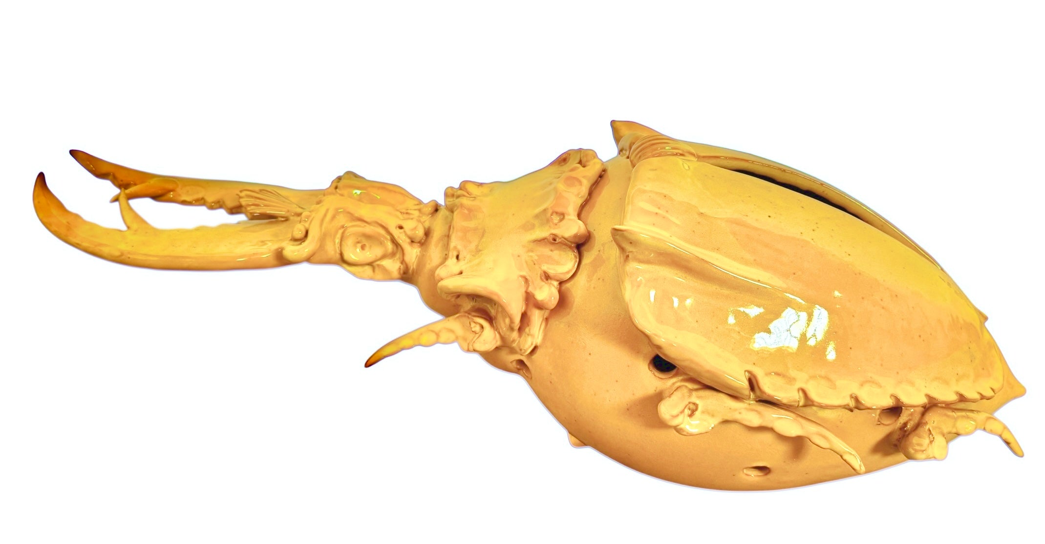 a large, high-gloss ceramic sculpture by Enza Fasano, shaped like a stylized beetle. The entire piece is finished in a warm, honey-yellow glaze. The beetle features prominent, curved mandibles at the front, a textured "collar" area, and a rounded, shell-like body with decorative ridges along the edges. The surface is smooth and reflective, catching the light across its organic contours.