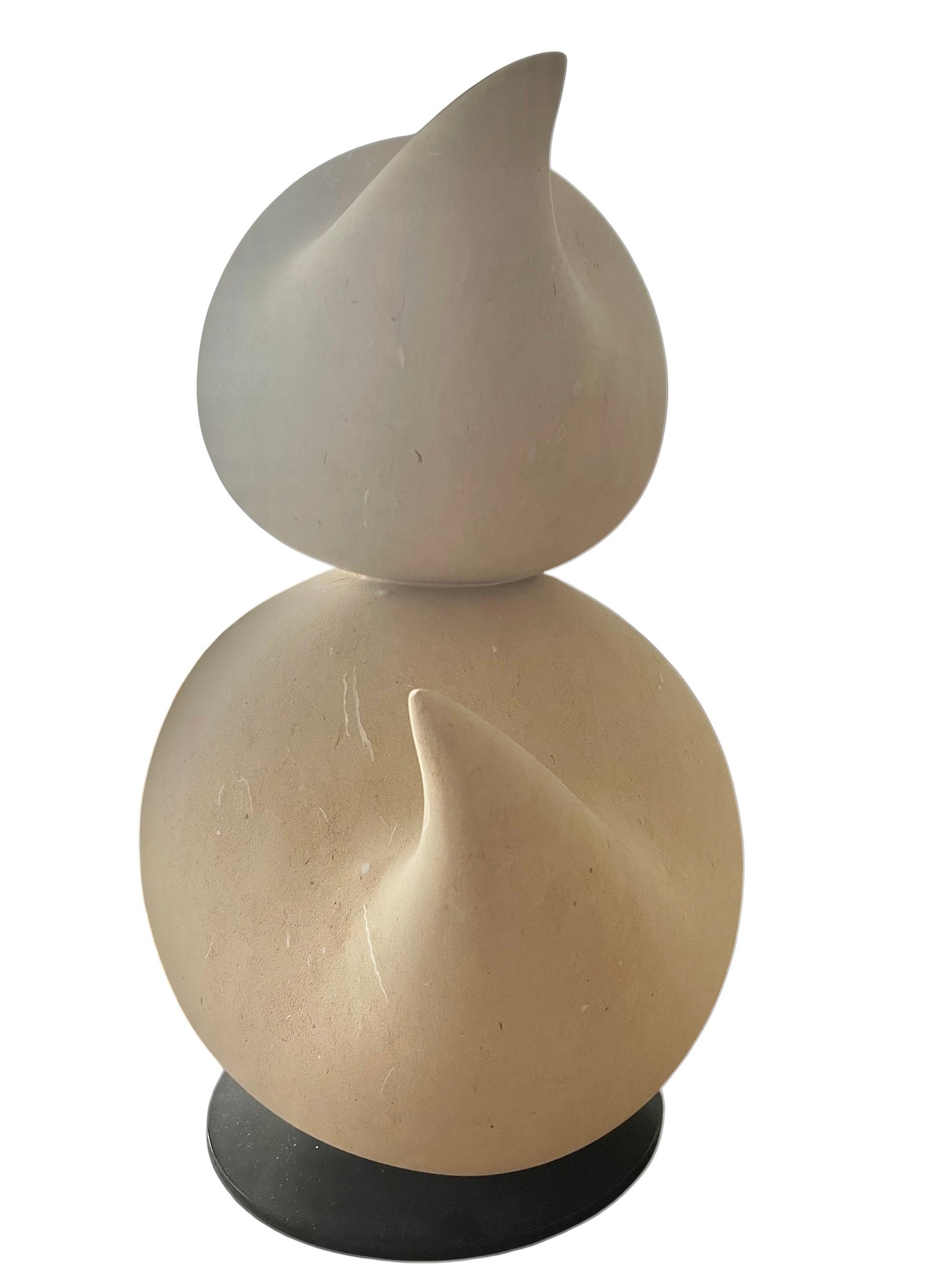 "Renzo Buttazzo's 'Lovers,' a sculpture made from Pietra Leccese featuring two stacked, rounded forms with subtle projections, on a black base."
"Modern sculpture of two smooth, light-colored forms stacked on top of each other, with a small horn-like protrusion on each."