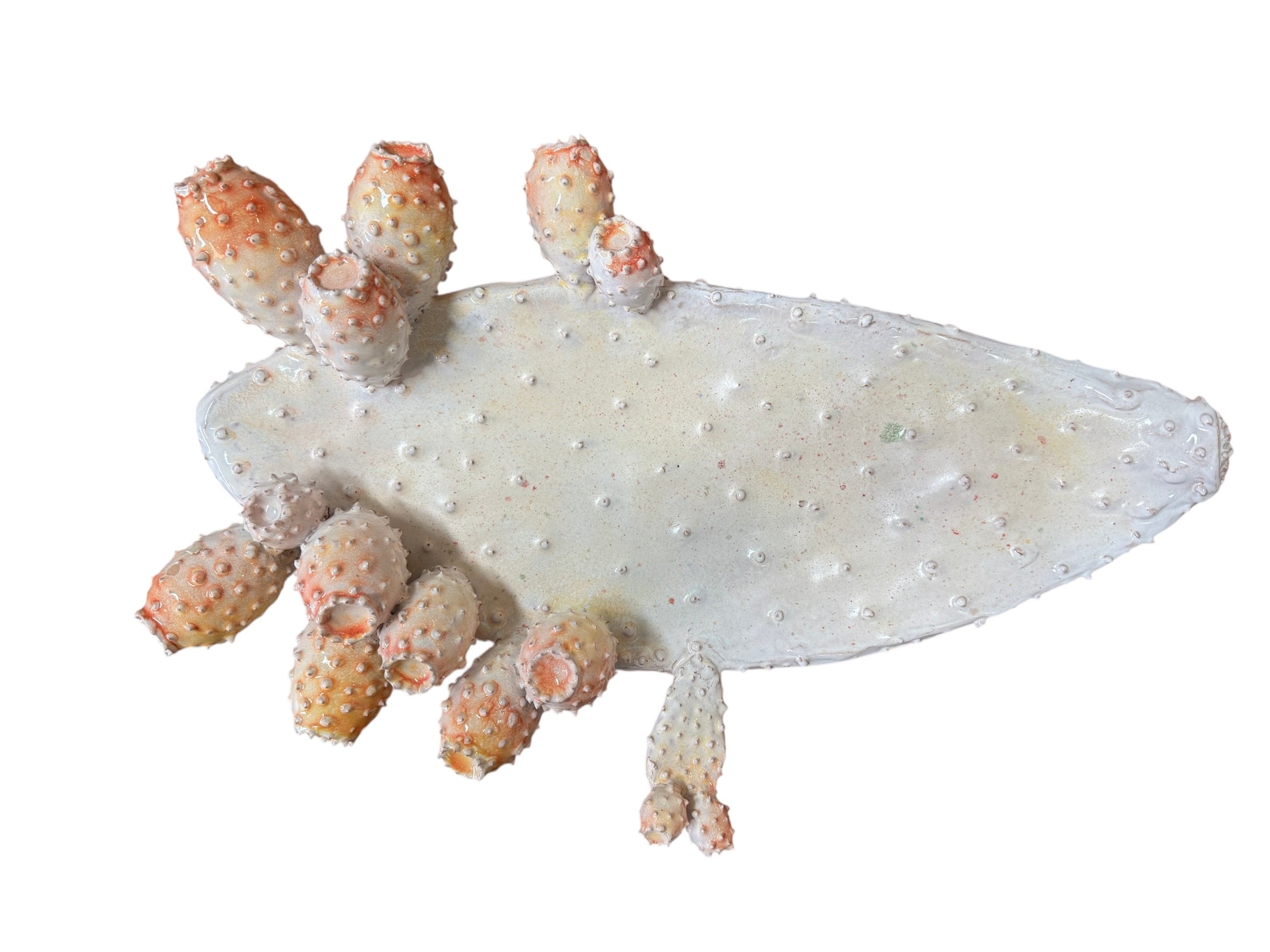 A white and orange, glazed ceramic platter in the shape of a prickly pear cactus pad with attached prickly pear fruit. The surface has raised dots representing spines. 
Handmade White Cactus Platter with Orange Accents- Italian Design by Enza Fasano Ceramiche