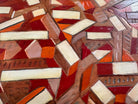 Close-up of a mosaic pattern with geometric shapes in various wood tones.