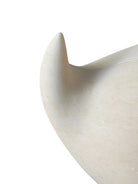 "Renzo Buttazzo's 'Lovers,' a sculpture made from Pietra Leccese featuring two stacked, rounded forms with subtle projections, on a black base."
"Modern sculpture of two smooth, light-colored forms stacked on top of each other, with a small horn-like protrusion on each."