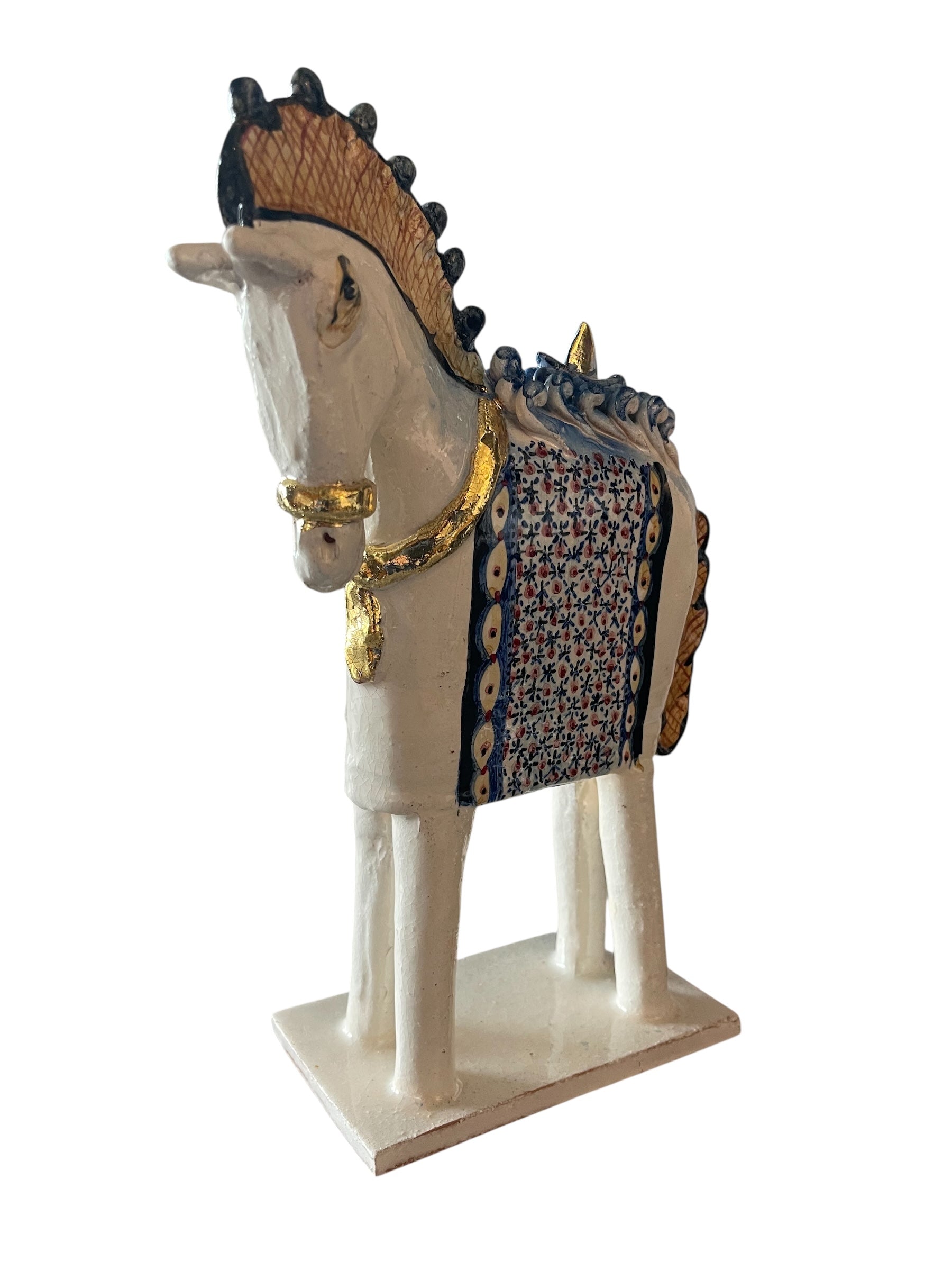 Ceramic horse by Domenico Pinto, featuring a white glazed body, geometric quilting on the saddle, gold accents, and 24Kt gold detailing. The horse stands on four legs and is placed on a white base.