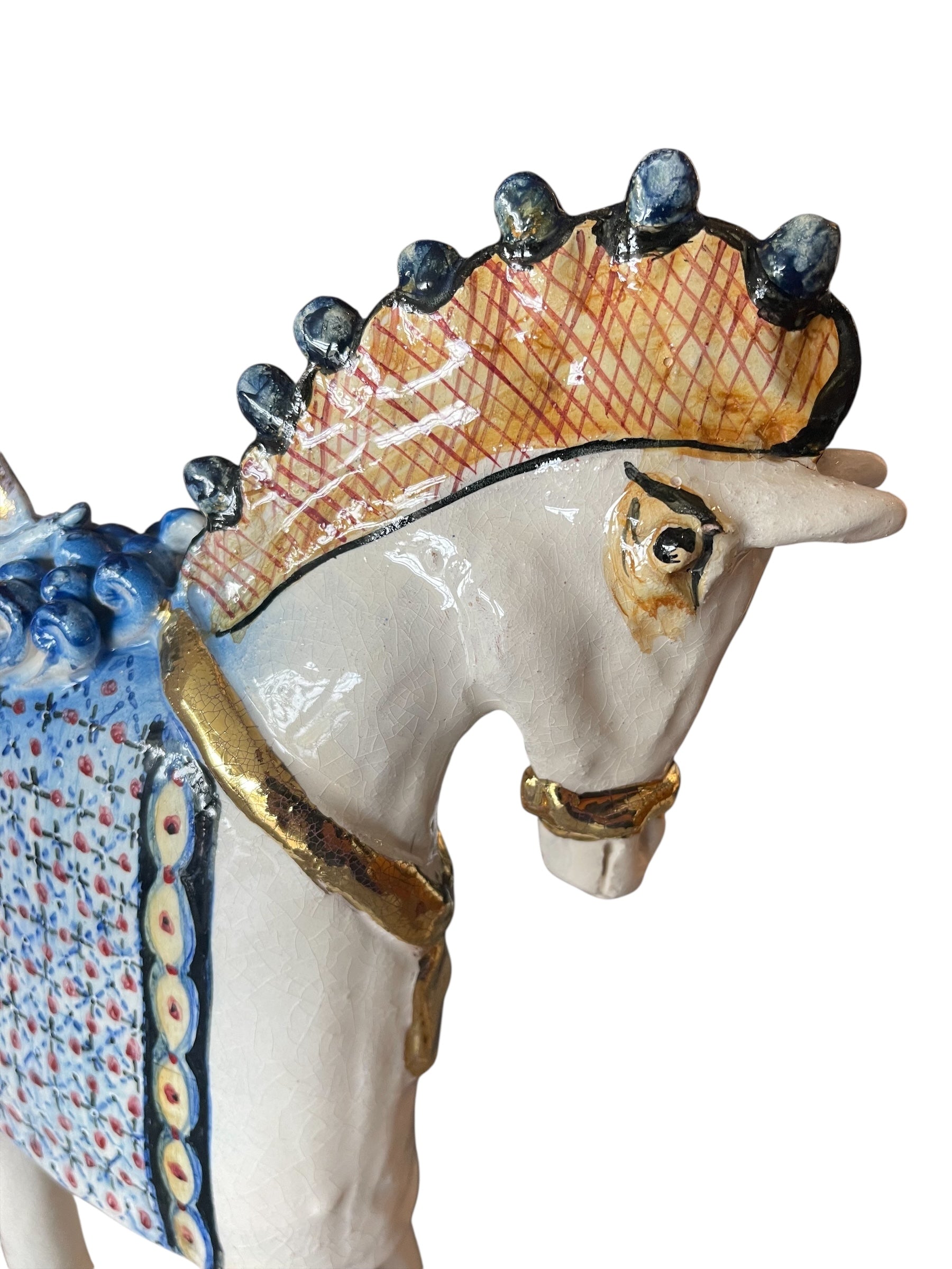 Ceramic horse by Domenico Pinto, featuring a white glazed body, geometric quilting on the saddle, gold accents, and 24Kt gold detailing. The horse stands on four legs and is placed on a white base.