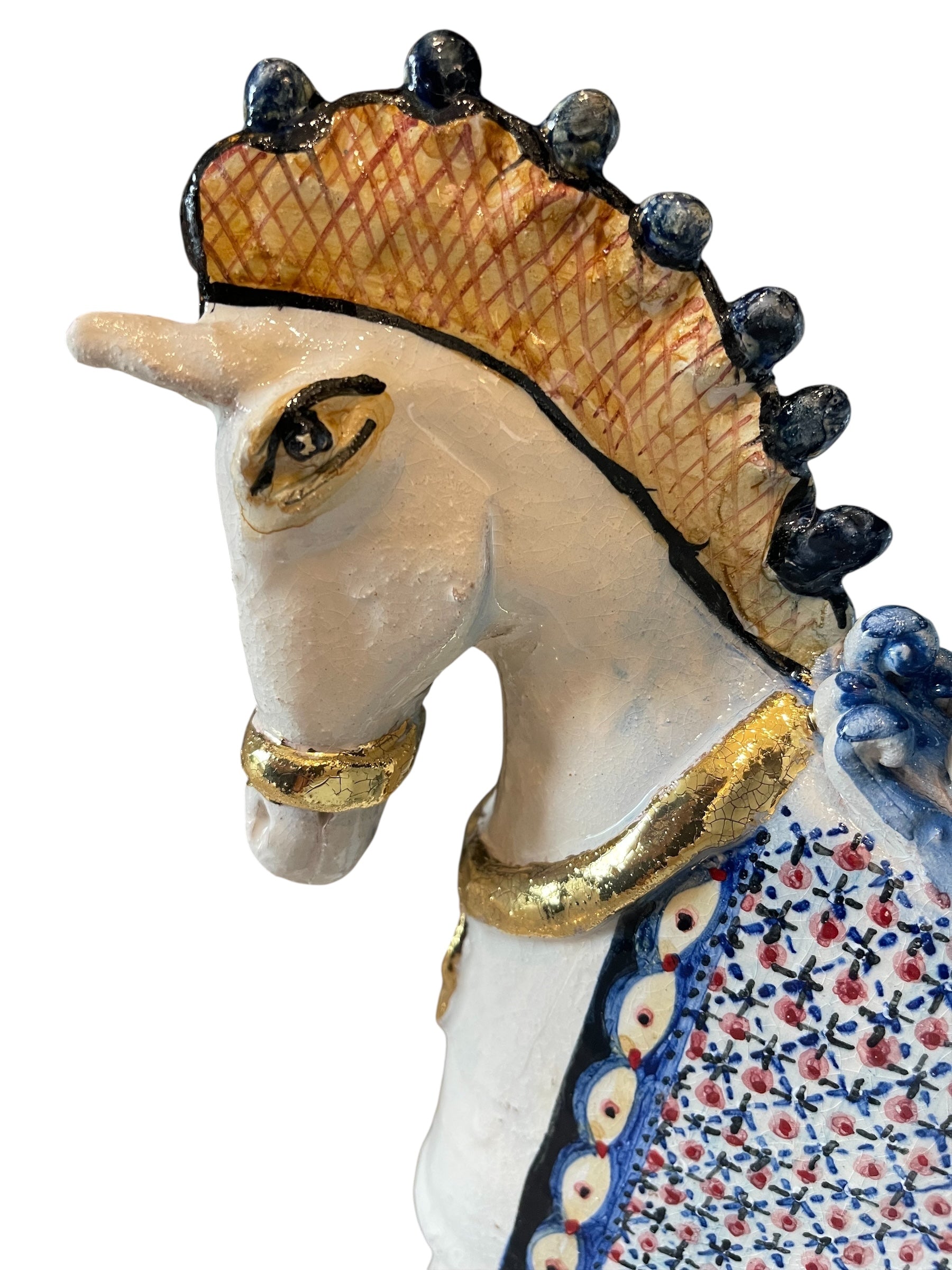 Ceramic horse by Domenico Pinto, featuring a white glazed body, geometric quilting on the saddle, gold accents, and 24Kt gold detailing. The horse stands on four legs and is placed on a white base.