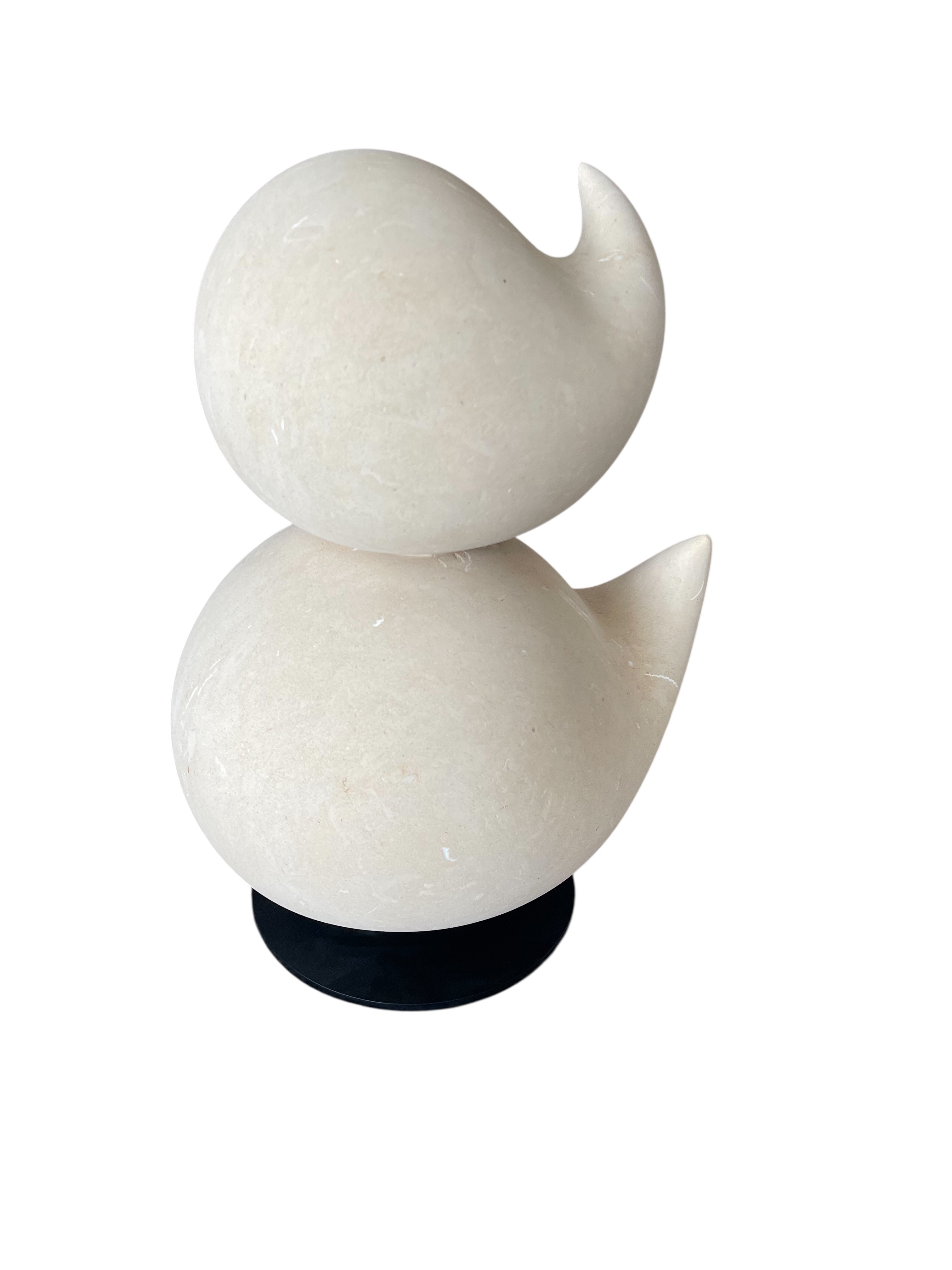 "Renzo Buttazzo's 'Lovers,' a sculpture made from Pietra Leccese featuring two stacked, rounded forms with subtle projections, on a black base."
"Modern sculpture of two smooth, light-colored forms stacked on top of each other, with a small horn-like protrusion on each."
"Lovers" A Sculpture by Renzo Buttazzo