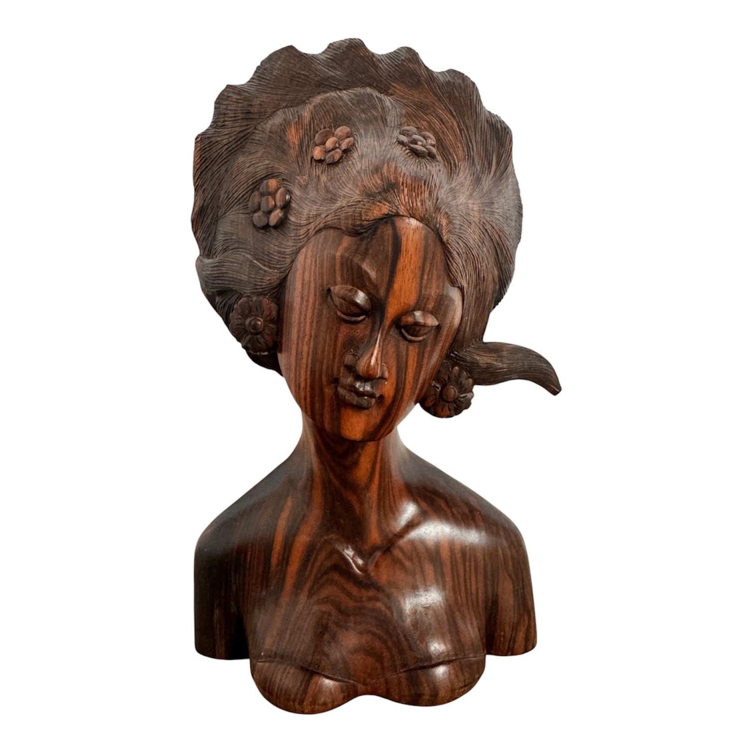 An elegant hand-carved bust of a woman made from rich, polished dark ebony wood with striking reddish-brown grain patterns running vertically through her face and chest. The sculpture features a serene expression with closed eyes, a slender nose, and relaxed lips. Her voluminous, textured hair rises upward in a Fan-like shape, intricately carved with fine lines and adorned with small, delicate flower details. The bust includes her bare shoulders and upper chest, resting on a flat base.