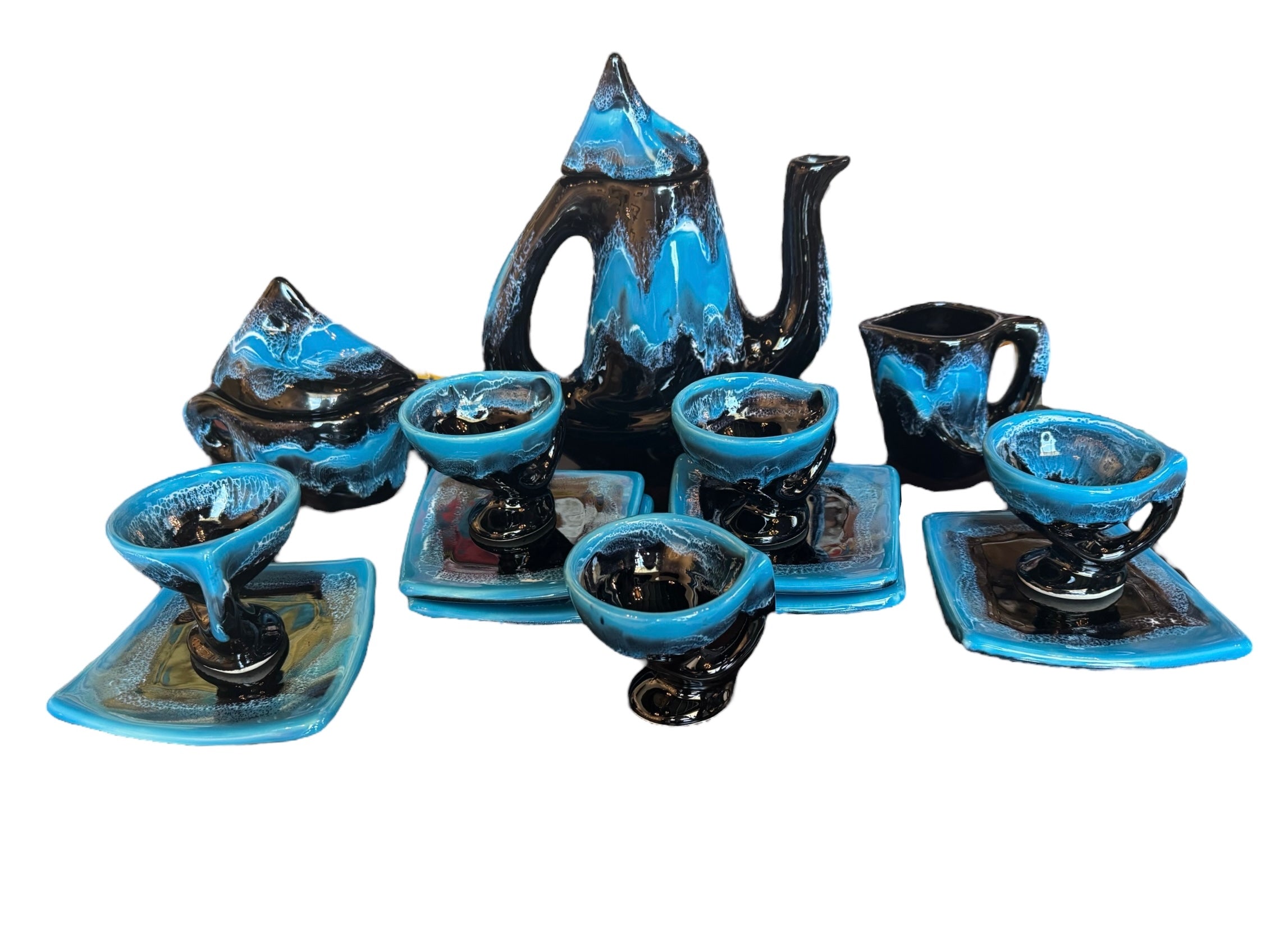 Complete mid-century ceramic tea set with teapot, sugar bowl, cups, and saucers, featuring a bold blue and black "lava drip" glaze reminiscent of Vallauris pottery.
Mid-Century Ceramic Tea Set , Attributed to the Style of Vallauris Ceramics