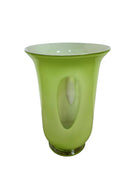 A mid-century modern, lime green cased-glass vase with a wide, flared rim and a thick, clear glass base. The exterior is a glossy chartreuse green, while the interior is lined with solid milk-white glass. The defining feature is a large, vertical oval cutout window that pierces directly through the center of the vase's body, creating an open-air negative space.