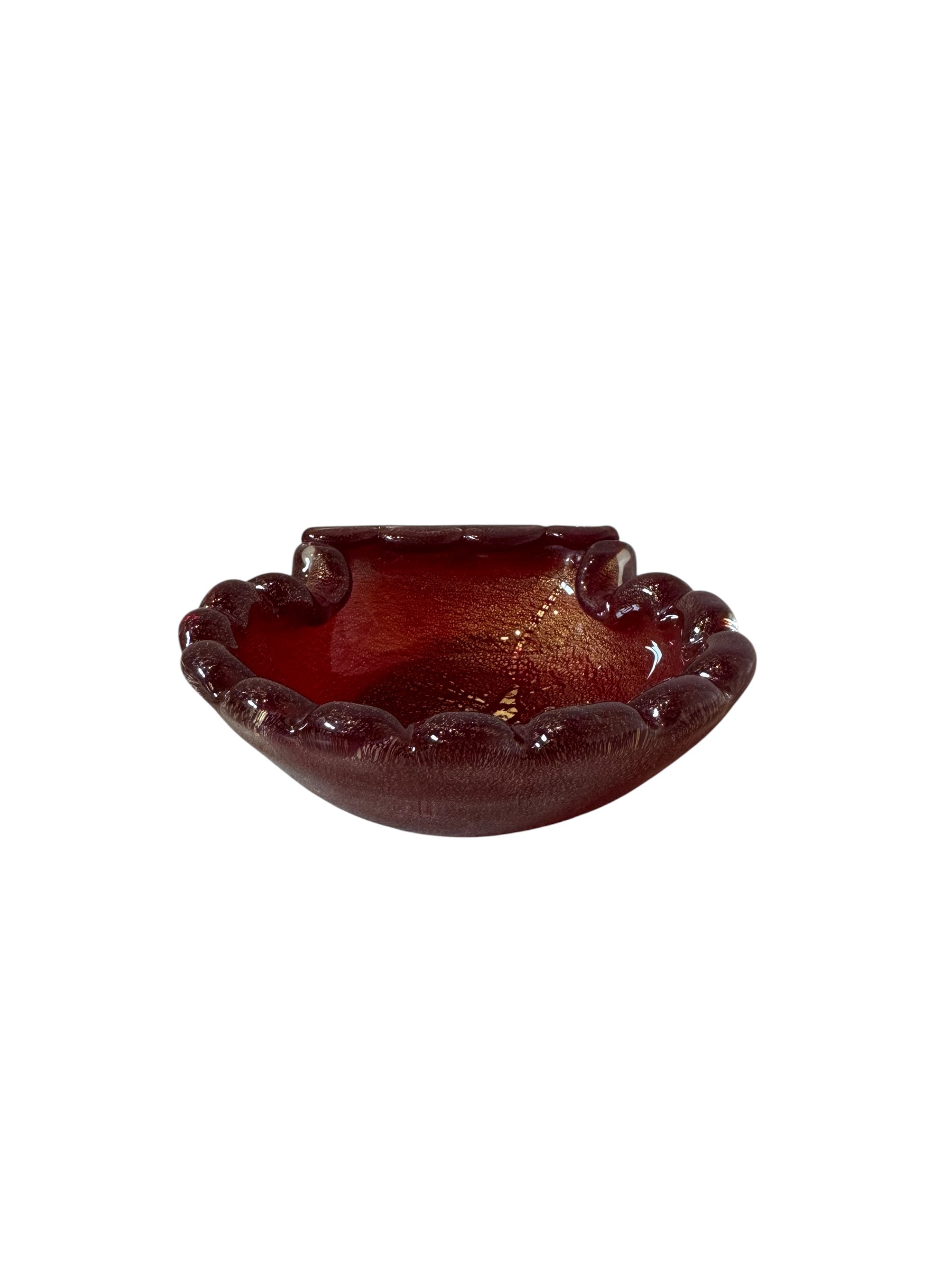 A handcrafted Murano glass bowl with a ruffled edge, deep red color, and gold specks created using the "oro zecchino" technique. The surface has a crackled gold pattern that reflects light, making it a striking decorative piece.
