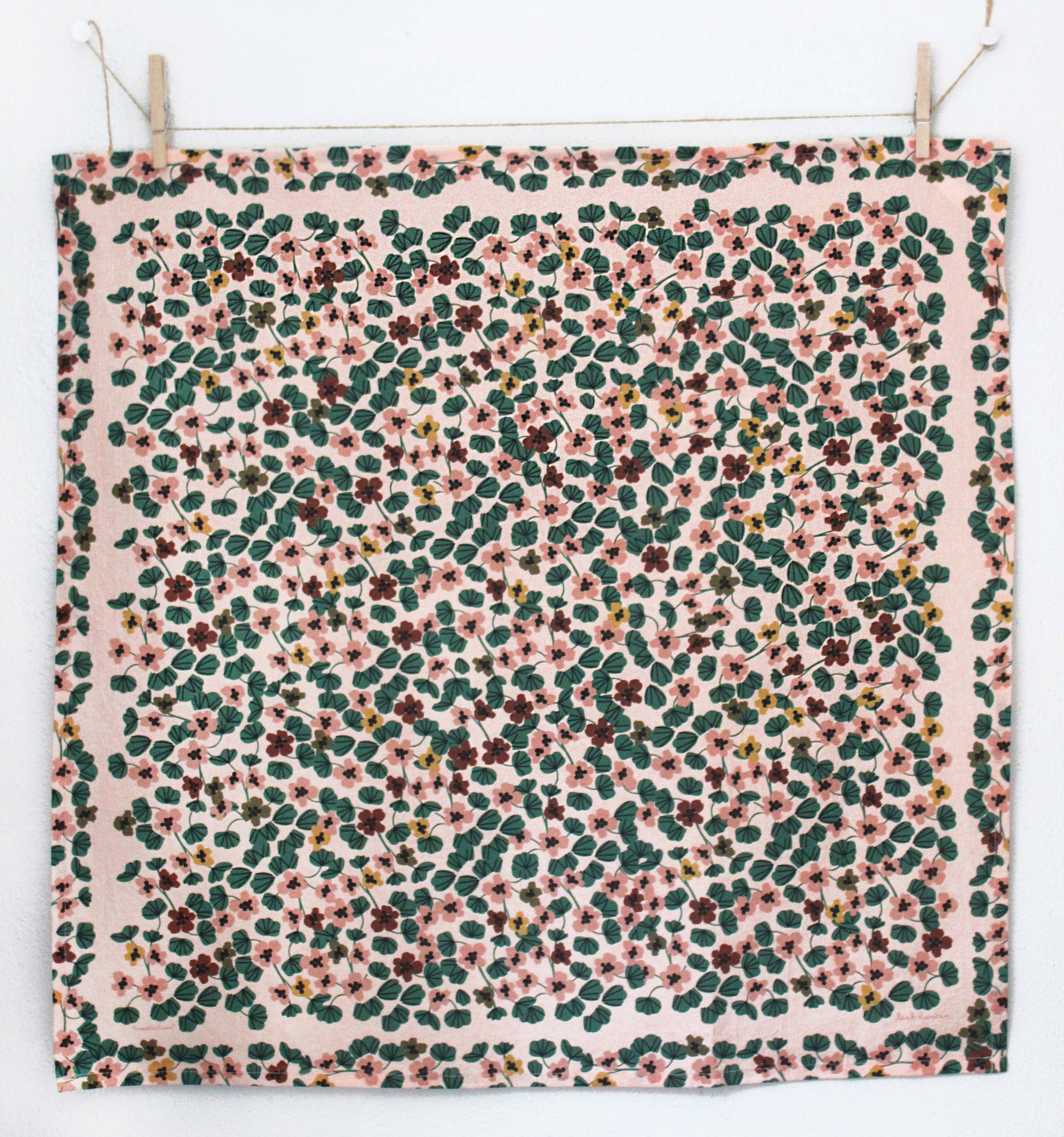 Floral patterned fabric hanging on a line with clothespins.