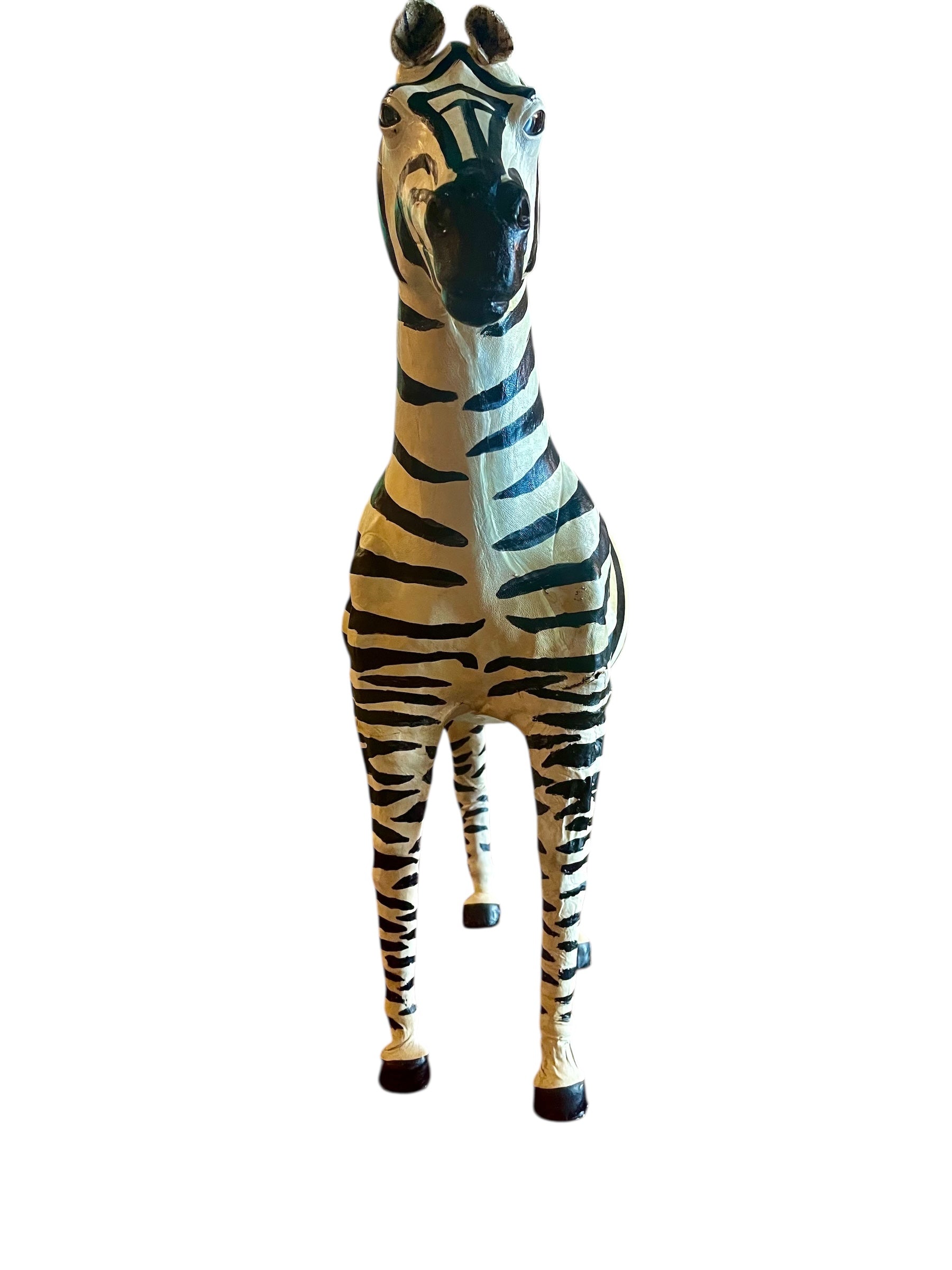 A full-length view of a standing zebra sculpture made from hand-painted leather. The sculpture features bold black and white stripes and shows signs of age, including slight yellowing and a tear on its leg.
Vintage
Antique
Art
Figurine
Decorative
Animal
Wear
Tear
Cream
Standing
Detailed
Full-length
Close-up