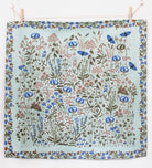 Floral patterned fabric hanging on a line with wooden pegs.