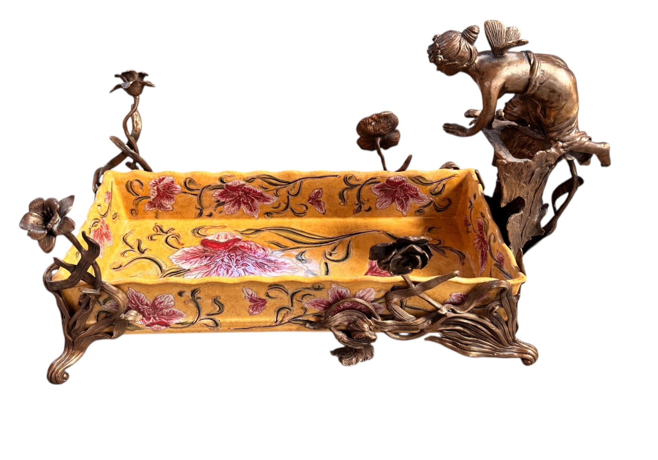A rectangular yellow porcelain jardiniere with hand-painted red flowers and green foliage, mounted in ornate gilt bronze. The bronze features scrolled feet, delicate floral stems, and a winged fairy nymph figure perched on one side.

