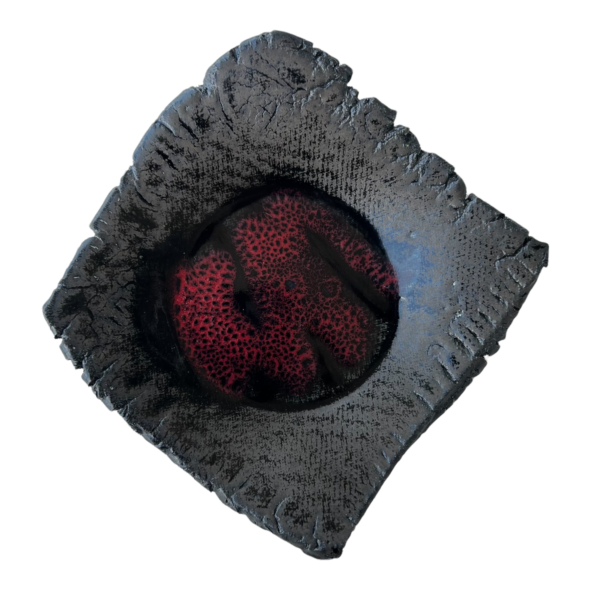 A black matte and glossy ceramic accent plate with a red cobalt organic center and slightly turned up corners. By local artist Rick Van Dyke.
